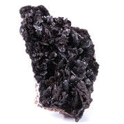 A large, impressive mineral specimen featuring a dense coverage of shiny, dark reddish-brown to black descloizite crystals in distinctive spearhead formations. The crystals, which show amber translucency, are arranged in a complex, overlapping pattern across the entire surface of the specimen. The piece is roughly triangular in shape when viewed from above, with the crystals forming dramatic, three-dimensional projections that create a textured, sculptural appearance.