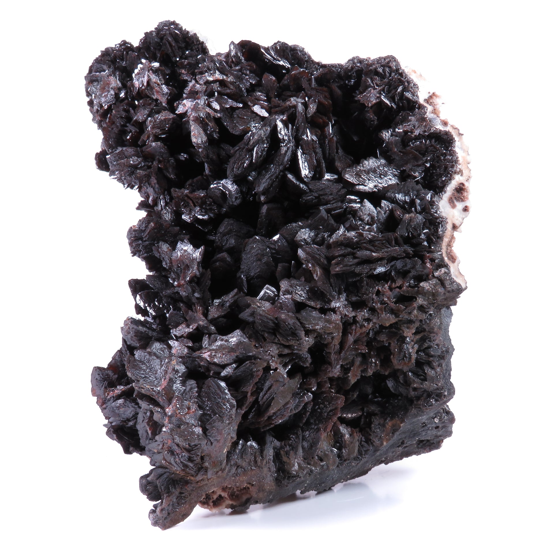 A large, impressive mineral specimen featuring a dense coverage of shiny, dark reddish-brown to black descloizite crystals in distinctive spearhead formations. The crystals, which show amber translucency, are arranged in a complex, overlapping pattern across the entire surface of the specimen. The piece is roughly triangular in shape when viewed from above, with the crystals forming dramatic, three-dimensional projections that create a textured, sculptural appearance.