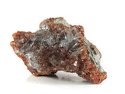 A striking mineral specimen featuring transparent, tabular celestine crystals jutting out from a rusty-red hematite-stained matrix. The crystals are glassy and well-formed, arranged in a bristling formation across the specimen's surface. The dramatic contrast between the clear, prismatic crystals and the deep red-brown matrix creates a natural sculptural effect.