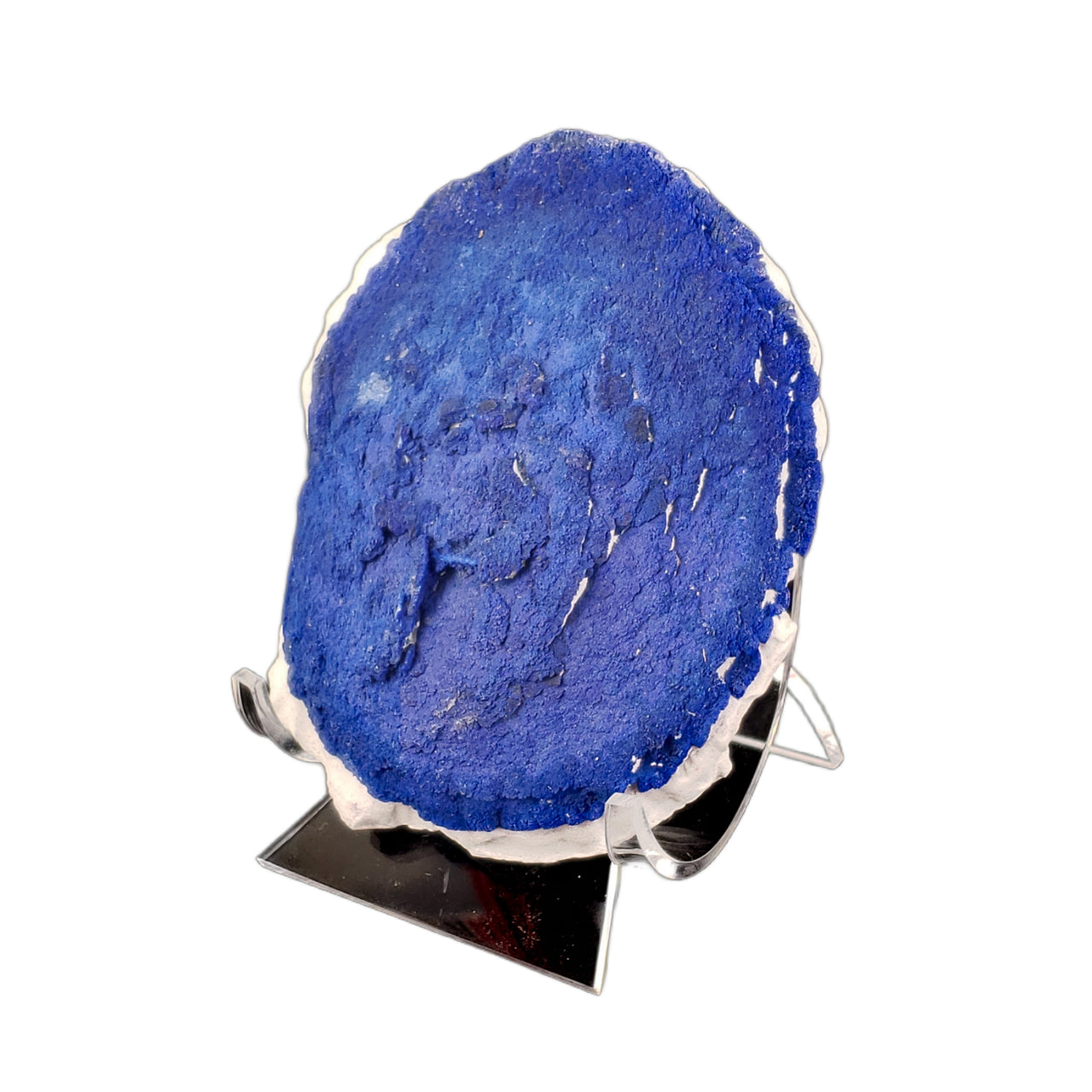 A large circular azurite formation displaying the classic 'sun' pattern, with a rich royal blue coloration and concentric textural details visible across its surface. The azurite disc sits on a thin band of white kaolinite matrix, creating a striking color contrast. The specimen shows the characteristic radiating structure typical of azurite suns, with a rough, crystalline texture across its face.