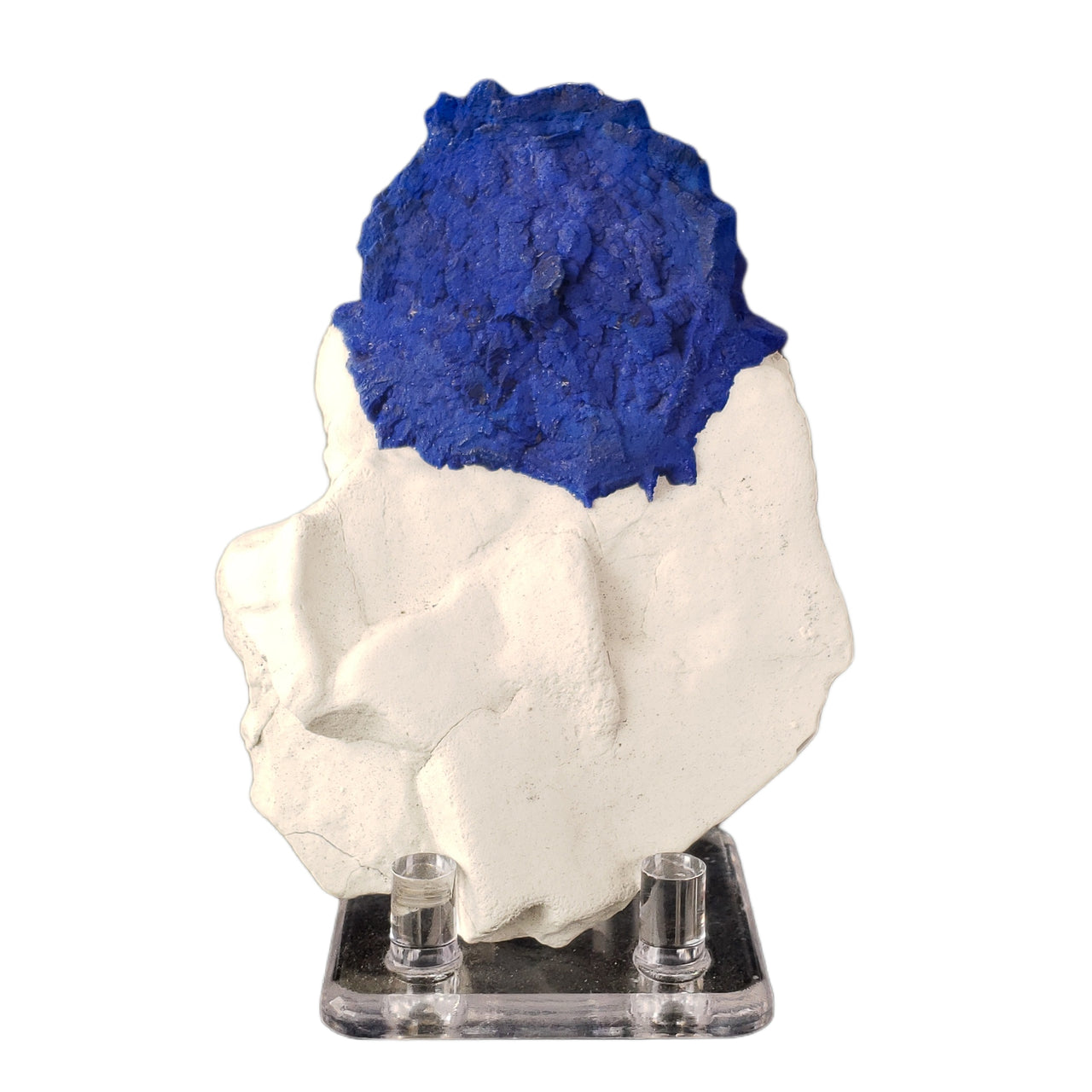 A vibrant blue circular formation of azurite, known as an azurite sun, sits atop a sculptural white kaolinite clay matrix. The deep royal blue azurite creates a striking contrast against the pure white kaolinite base. The specimen's natural positioning shows off the distinctive circular growth pattern of the azurite against the black background.