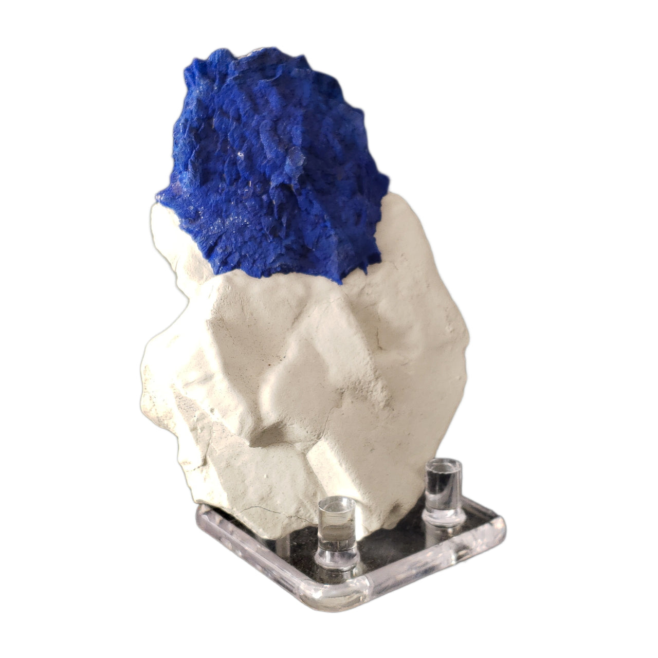 A vibrant blue circular formation of azurite, known as an azurite sun, sits atop a sculptural white kaolinite clay matrix. The deep royal blue azurite creates a striking contrast against the pure white kaolinite base. The specimen's natural positioning shows off the distinctive circular growth pattern of the azurite against the black background.